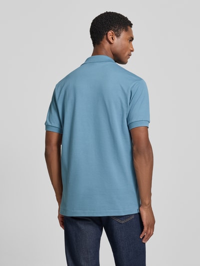 Męski model nosi Regular Fit Poloshirt aus reiner Baumwolle Modell 'CORE' von Lacoste w kolorze niebieskim, gładka faktura, Ganzkörperansicht Rückansicht. Koszulka polo męska Lacoste