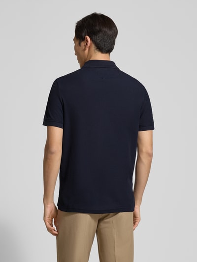 Männermodel trägt Regular Fit Poloshirt aus reiner Baumwolle von Tommy Hilfiger, Optik: Unifarben, Materialverarbeitung: Piqué, Ganzkörperansicht Rückansicht.