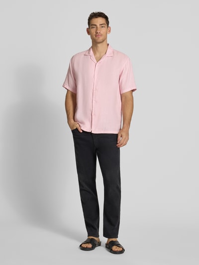 Männermodel trägt Regular Fit Leinenhemd mit Reverskragen von MCNEAL in Rosa, reine Leinenstruktur, kurze Ärmel, Ganzkörperansicht von vorne.