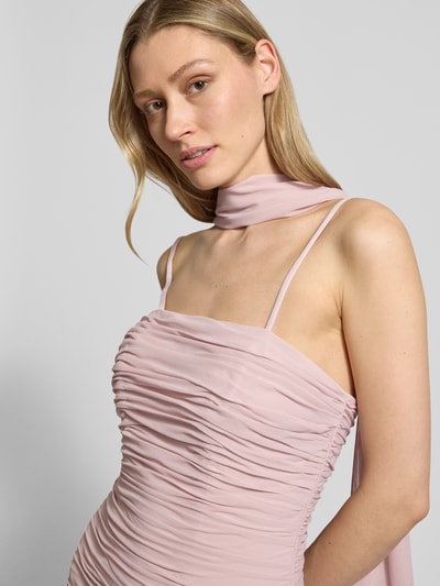 Frauenmodel trägt Maxikleid im Off-Shoulder-Look mit Raffungen von Unique aus Chiffon in zartem Rosaton, Figurbetont, Nahaufnahme Oberkörper. Rückenlänge bei Größe 36: 136 cm, Brustweite bei Größe 36: 37 cm.