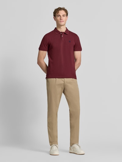 Męski model nosi Regular Fit Poloshirt mit Label-Stitching von MCNEAL z bawełny, listwa guzikowa, długość tyłu w rozmiarze M 70 cm, Ganzkörperansicht von vorne.