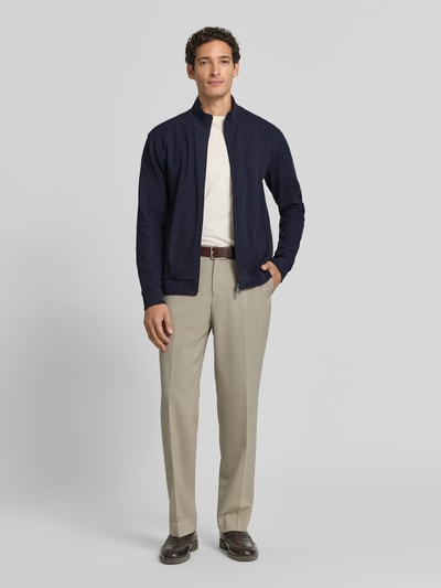Männermodel trägt Regular Fit Sweatjacke aus Baumwoll-Mix Modell 'Structure' von BOSS in Dunkelblau, hellem Shirt, beige Hose, Ganzkörperansicht von vorne, Herren Sweatjacke von BOSS.