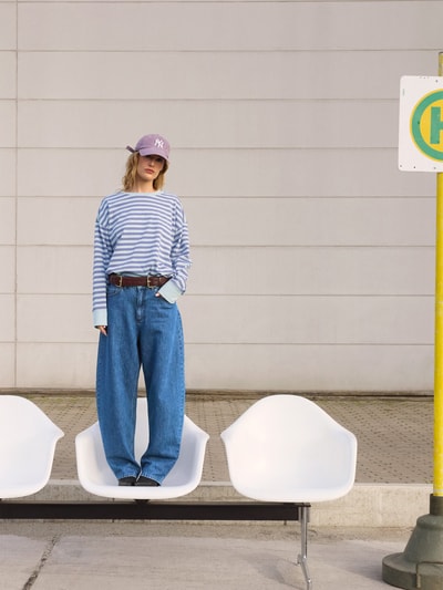Frauenmodel trägt Barrel-Leg-Fit Jeans - curated by Tinvcb von Tinvcb, blaue weite Damen Jeans, glatte Struktur, Ganzkörperansicht von vorne.