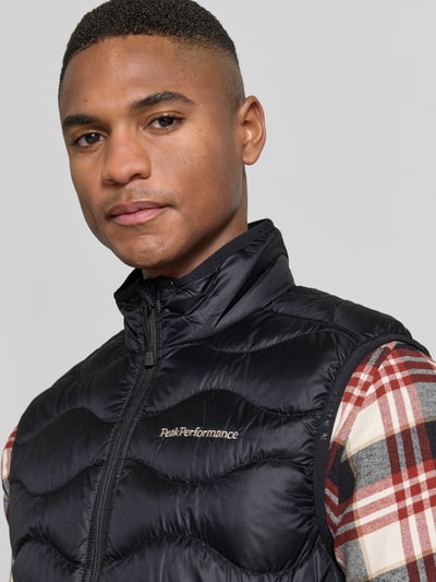 Männermodel trägt Regular Fit Weste aus reinem Alcantara Modell 'Helium' von Peak Performance, Stepp-Optik, Logo-Stitching, Nahaufnahme Oberkörper.