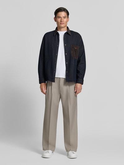 Mannelijk model draagt Overshirt met Kentkraag in Cord-look en Label-Patch van Armani Exchange in regular fit, donkerblauw met bruine details, zichtbare knoopsluiting en borstzak, overhemdkraag, sportmanchetten, lengte maat M 70 cm, voorkant volledige lichaamsweergave.
