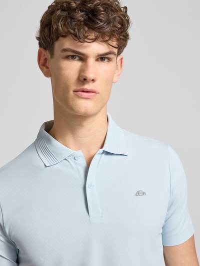 Męski model nosi Slim Fit Poloshirt mit Logo Modell 'EDMOND' od Ellesse, jasnoniebieski, materiał z domieszką stretchu, krój slim fit, widok na górną część ciała z przodu.