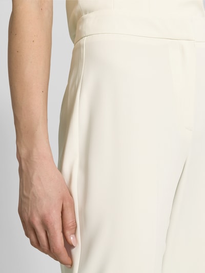 Vrouwenmodel draagt Hose mit Bügelfalten van Jake*s Cocktail, regular fit, crèmekleur, gladde textuur, detailopname heup.
