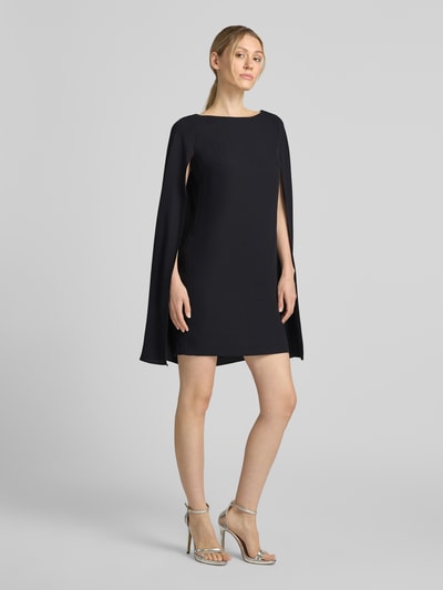 Modelka nosi A-Linien Cocktailkleid mit Cape od Lauren Ralph Lauren, ciemny kolor, proste linie, gładka tekstura, całopostaciowy widok z przodu.