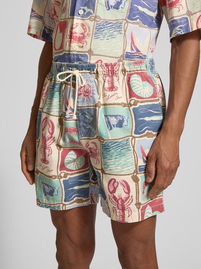 Männermodel trägt Shorts aus reiner Baumwolle von Gant mit maritimen Mustern in Blau, Beige, Rot, elastischem Bund, Nahaufnahme Oberkörper.