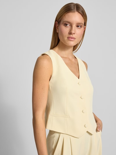 Frauenmodel trägt Regular Fit Weste mit V-Ausschnitt von Christian Berg Cocktail im hellen Farbton, Elastischer-Material-Mix, durchgängige Knopfleiste, Rückenlänge bei Größe 36: 46 cm, Nahaufnahme Oberkörper.