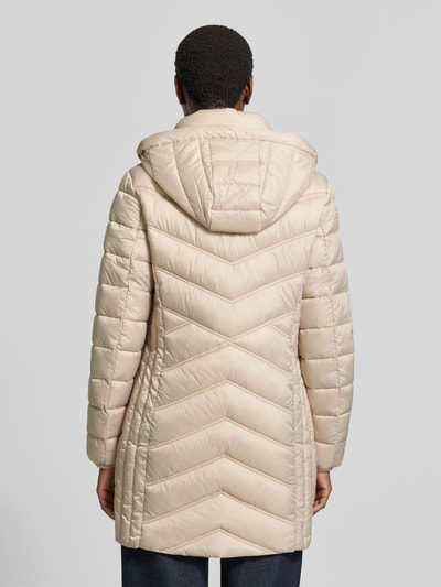 Männermodel trägt Steppmantel mit Zweiwege-Reißverschluss von Christian Berg Woman Selection, krój slim fit, beżowy, tekstura pikowana, długa kurtka, kaptur z troczkiem, kieszenie na suwak, szerokość ramion w rozmiarze 36: 40 cm, szerokość w biuście w rozmiarze 36: 48 cm, długość tyłu w rozmiarze 36: 83 cm, długość rękawa w rozmiarze 36: 65 cm, widok całej sylwetki z tyłu