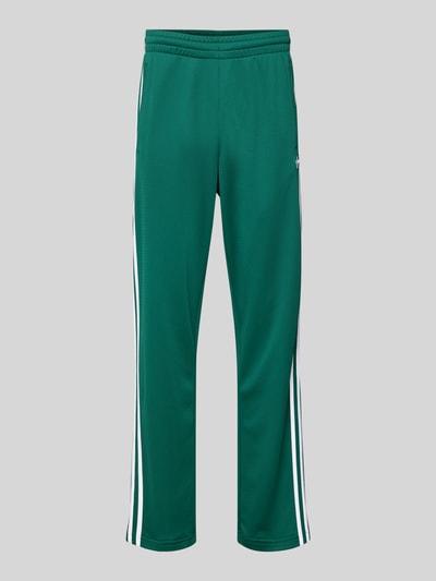 Productfoto, Sweatpants met elastische tailleband van adidas Originals in groen met witte strepen, los vallende fit, zijzakken, label-stitching, binnenbeenlengte maat M 81 cm