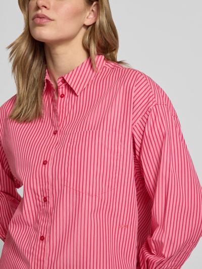 Frauenmodel trägt Relaxed Fit Bluse mit Brusttasche Modell 'JAMIE' von JJXX in Pink mit feinen Streifen, reine Baumwolle, Nahaufnahme Oberkörper.