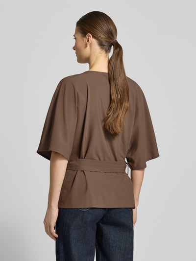 Vrouwenmodel draagt Relaxed Fit blouse uit viscosemix model 'Rikas' van MOS MOSH, bruin, met afneembaar stoffen band, halflange mouwen, ronde hals, ruglengte maat S 63 cm, mouwlengte maat S 28 cm, textuur glad, volledig zicht van achteren.