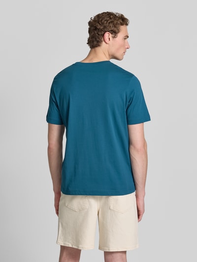 Männermodel trägt Regular Fit T-Shirt aus reiner Baumwolle von Tom Tailor, jednokolorowy, krój regular fit, nadruk z logo, dekolt:, krótki rękaw, dżersej, bawełna; Ganzkörperansicht Rückansicht