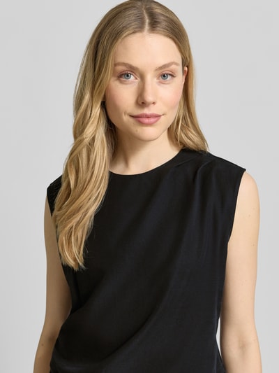 Modelka nosi Top aus Lyocell-Leinen-Mix in asymmetrischer Form von JAKE*S STUDIO WOMAN, czarny kolor, okrągły dekolt, drapowania, widoczne gładkie tekstury, długość tyłu w rozm. 36: 54 cm, zbliżenie na górną część ciała