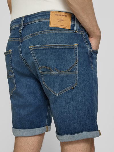 Männermodel trägt Jeansshorts mit Umschlag Modell 'RICK' von Jack & Jones, Farbe Blau, Baumwoll-Mix mit Stretch-Anteil, Regular-Fit, Detailaufnahme Rückansicht.
