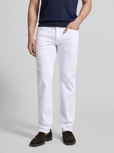 Männermodel trägt Regular Fit Jeans im Used-Look Modell 'Cadiz' von BRAX aus weißem Baumwoll-Mix mit Stretch-Anteil, Eingrifftaschen, Ganzkörperansicht von vorne. Bundweite 44 cm, Innenbeinlänge 80 cm bei Größe 32/32.