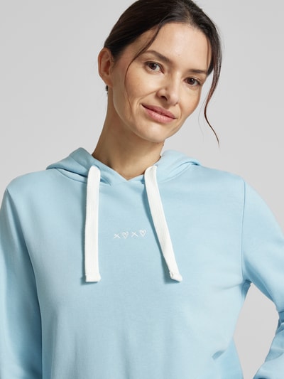 Frauenmodel trägt Regular Fit Hoodie aus Baumwoll-Mix von Tom Tailor Denim in Hellblau mit Stickerei, Nahaufnahme Oberkörper.