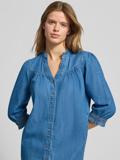 Frauenmodel trägt Fließendes Jeanskleid aus reiner Baumwolle Modell 'RAYA' von Only in Denim-Optik mit Puffärmeln und Knopfleiste, Nahaufnahme Oberkörper.