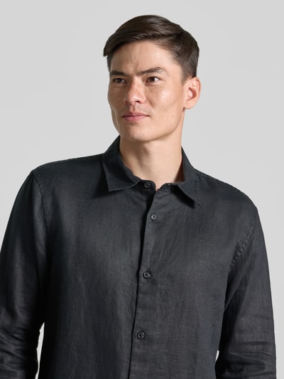 Männermodel trägt Regular Fit Leinenhemd mit Kentkragen von GAP, reines Leinen, Knopfleiste, dunkle Farbe, Nahaufnahme Oberkörper.
