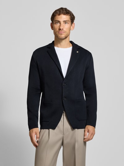 Männermodel trägt Regular Fit Cardigan mit wol, Materiaalmix en Reverskraag van Manuel Ritz in tricotlook met opgestikte zakken, ruglengte 74 cm, mouwlengte 61 cm, vooraanzicht van het hele lichaam.