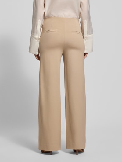 Vrouwenmodel draagt beige Stoffhose met Geßäßtaschen Modell 'KIMBERLEY' van SEDUCTIVE, losvallende pasvorm, viscose-mix, Ganzkörperansicht achterkant.