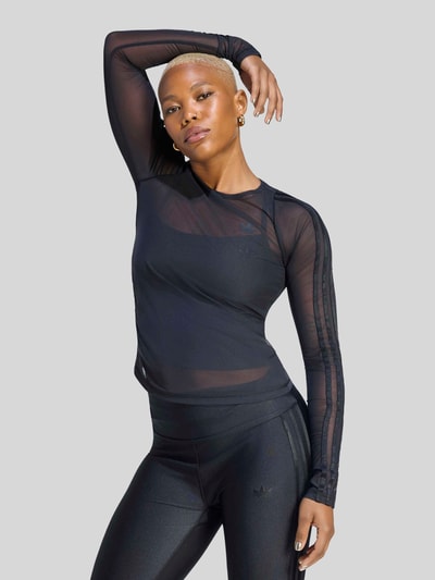 Vrouwenmodel draagt Regular Fit Sport-Langarmshirt met Logo-Detail van adidas Training, mat zwart, uni, mesh met Spitze, ronde hals, lange mouwen, rolzoom, logo-applicatie, detailopname bovenlichaam.
