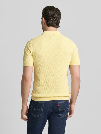 Männermodel trägt Regular Fit Poloshirt mit Strukturmuster von MCNEAL in Gelb, reine Baumwolle, Strick-Optik, Ganzkörperansicht Rückansicht.