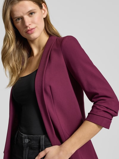 Kobiece model prezentuje Blazer mit Schalkragen od PIECES, luźny krój, jednolity kolor, szalowy kołnierz, tkanina gładka. Zbliżenie górnej części ciała.
