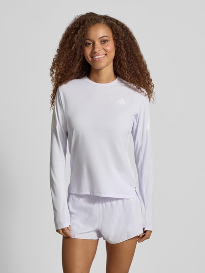 Frauenmodel trägt Regular Fit Sport-Langarmshirt mit Logo-Print Modell 'adi365///' von adidas, helllila, glatte Textur, Ganzkörperansicht von vorne, Damen Sport-Langarmshirt von adidas Training.