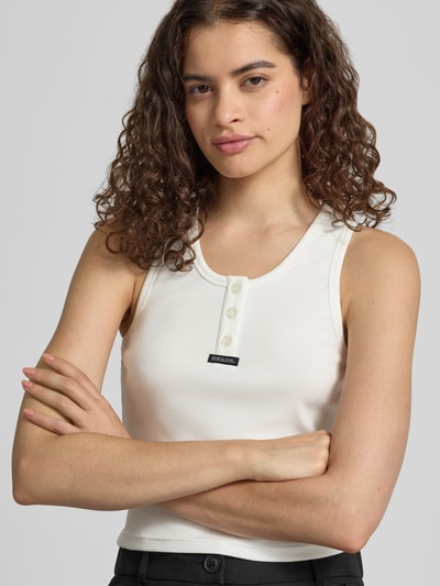 Kobiece modelka nosi Slim Fit Top aus Baumwolle-Mix mit Logo-Print od marki, kolor biały, mieszanka bawełny, nadruk z logo, Listwa guzikowa, długość tyłu w rozmiarze S: 44 cm, krój slim fit, zbliżenie na górną część ciała.