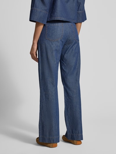 Frauenmodel trägt Flared Hose mit aufgesetzten Taschen von Jake*s Collection in Dunkelblau, sichtbare Gesäßtaschen, Ganzkörperansicht Rückansicht.
