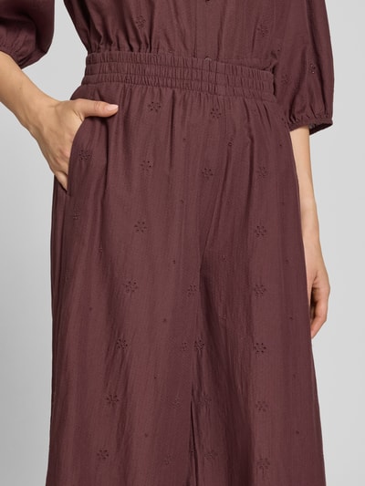 Frauenmodel trägt Regular Fit Culotte mit Stickereien von Marc O'Polo DENIM in Dunkelrot mit feiner Textur, Nahaufnahme Oberkörper.