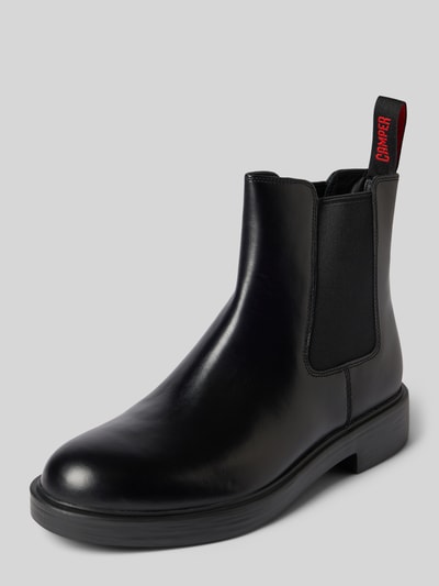 Produktfoto, schwarze Boots aus echtem Leder Modell 'Dean' von Camper, abgerundete Form, 3 cm Absatz, Logo-Detail, glatte Textur, neutraler Hintergrund