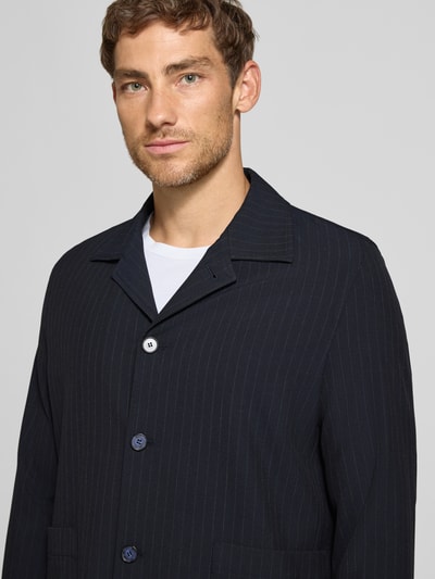 Männermodel trägt Oversized Fit Freizeithemd mit Viskose-Anteil Modell 'Malte' von CINQUE, dunkle Nadelstreifen, Nahaufnahme Oberkörper.