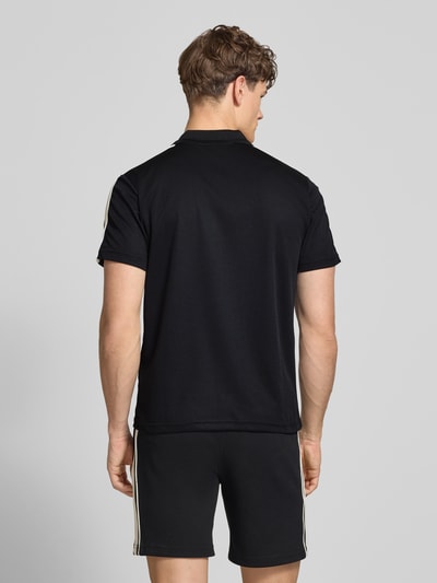 Męski model nosi Regular Fit Poloshirt mit Logo-Stitching Modell 'EGEO' od SERGIO TACCHINI, czarny, krótki rękaw, poliestrowa tekstura, krój regular fit, widok całej sylwetki z tyłu. Długość tyłu w rozmiarze M: 66 cm.
