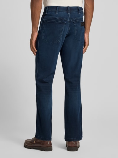 Männermodel trägt Straight Fit Jeans im 5-Pocket-Design Modell 'Texas' von Wrangler, dunkelblauer Baumwoll-Mix, Ganzkörperansicht Rückansicht.