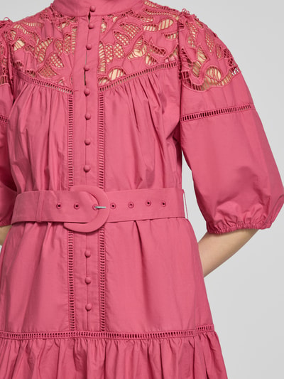 Frauenmodel trägt knielanges Kleid mit Spitze und Gürtel Modell 'CATY' von SUNCOO PARIS in Pink, reine Baumwolle, taillierter Schnitt, Nahaufnahme Oberkörper.
