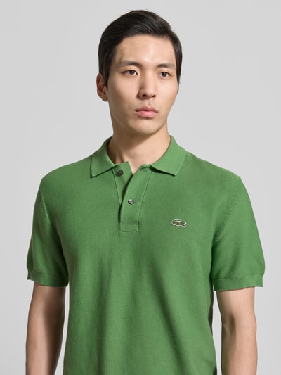 Männermodel trägt Regular Fit Poloshirt aus reiner Baumwolle von Lacoste, Optik: Unifarben, Logo-Stitching, Nahaufnahme Oberkörper.