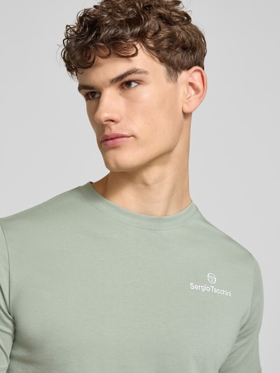Männermodel trägt Regular Fit T-Shirt mit Logo-Print von SERGIO TACCHINI in Hellgrün, reine Baumwolle, Nahaufnahme Oberkörper.