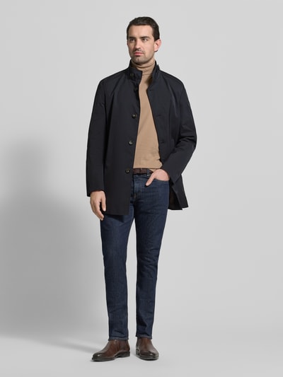 Männermodel trägt Mantel mit durchgehender Knopfleiste von CINQUE in Dunkelblau, gerade Passform, Stehkragen, Eingrifftaschen, Ganzkörperansicht von vorne