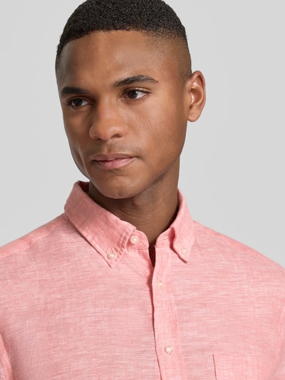 Männermodel trägt Slim Fit Leinenhemd mit Brusttasche von Christian Berg Men in Rosa, Button-Down-Kragen, Nahaufnahme Oberkörper.