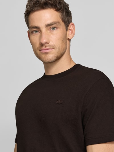 Mężczyzna nosi Regular Fit T-Shirt aus reiner Baumwolle von Lacoste, czarny, jednolity, krój regular fit, łatka z logo, okrągły dekolt, krótki rękaw, drobny dzianinowy materiał, bawełna, zbliżenie górnej części ciała