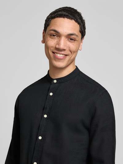 Męski model nosi Slim Fit Freizeithemd aus Baumwoll-Leinen-Mix Modell 'CAIDEN' von Only & Sons, kolor czarny, długie rękawy, mao kołnierzyk, pełna listwa guzikowa, gładka faktura tkaniny, widok z przodu, zbliżenie na górną część ciała.