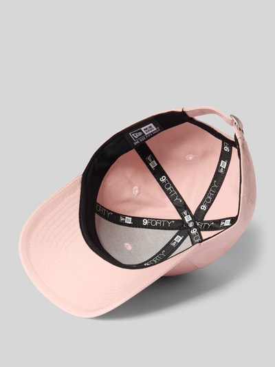 Produktfoto, Basecap aus reiner Baumwolle von New Era, rosa Farbe, verstärkter Schirm mit Steppnähten, Motiv-Applikation, verstellbarer Riegel, Innenansicht