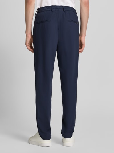 Männermodel trägt Slim Fit Anzughose mit Tunnelzug Modell 'GENIUS' von BOSS, Unifarben, Four-Way-Stretch, Ganzkörperansicht Rückansicht.