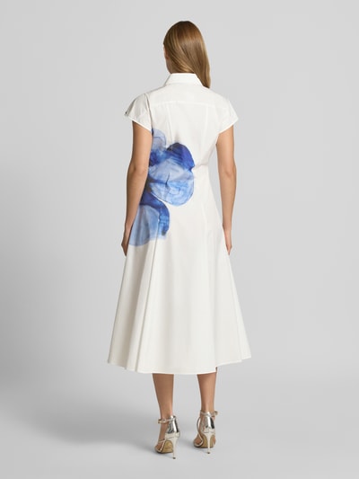 Frauenmodel trägt Ausgestelltes Freizeitkleid aus reiner Baumwolle Modell 'GIORNO' von MAX&Co., Optik: Unifarben, florales Muster, Midi-Länge, Kimonoärmel, Popeline, große blaue Blumenapplikation auf weißem Stoff, Ganzkörperansicht Rückansicht.