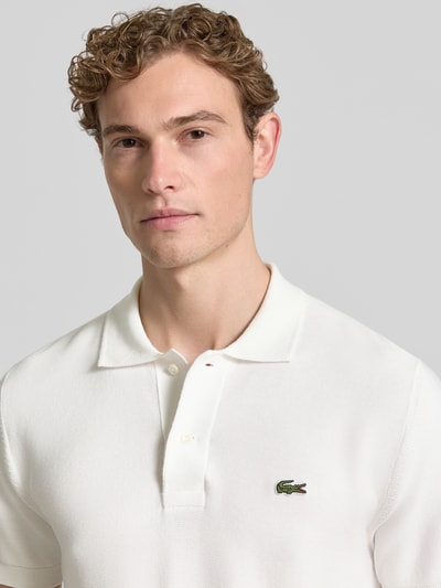Männermodel trägt Regular Fit Poloshirt aus reiner Baumwolle von Lacoste, Optik: Unifarben, Logo-Stitching, Nahaufnahme Oberkörper.