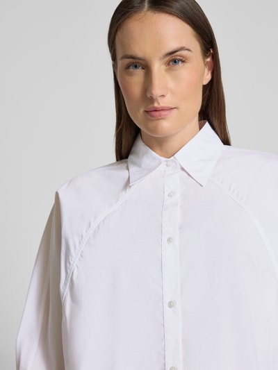 Frauenmodel trägt Oversized Hemdbluse aus reiner Baumwolle Modell 'BELENTA' von BOSS Orange, unifarben, Nahaufnahme Oberkörper.